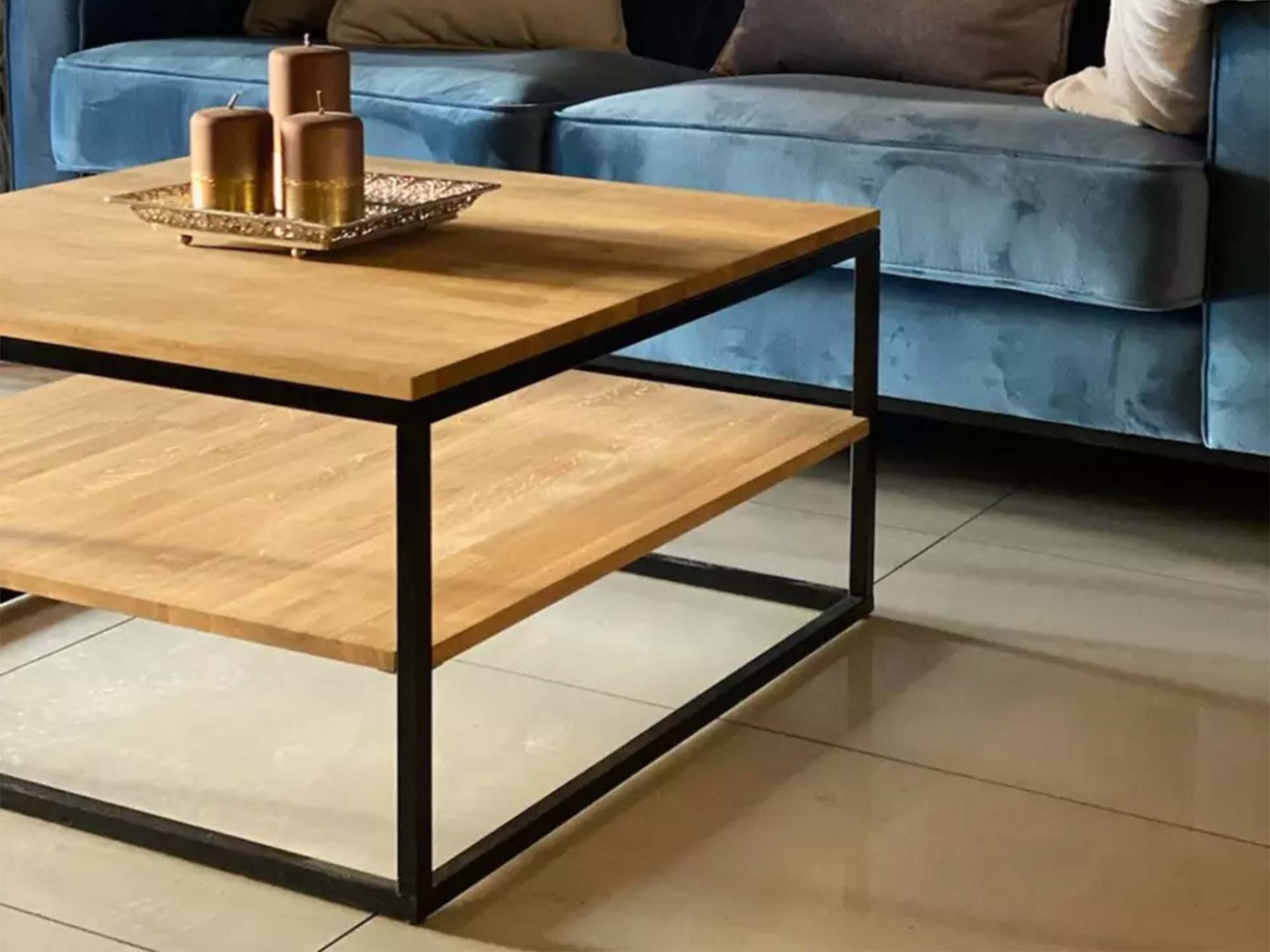 Stolik kawowy dębowy loft z półką przy niebieskiej sofie