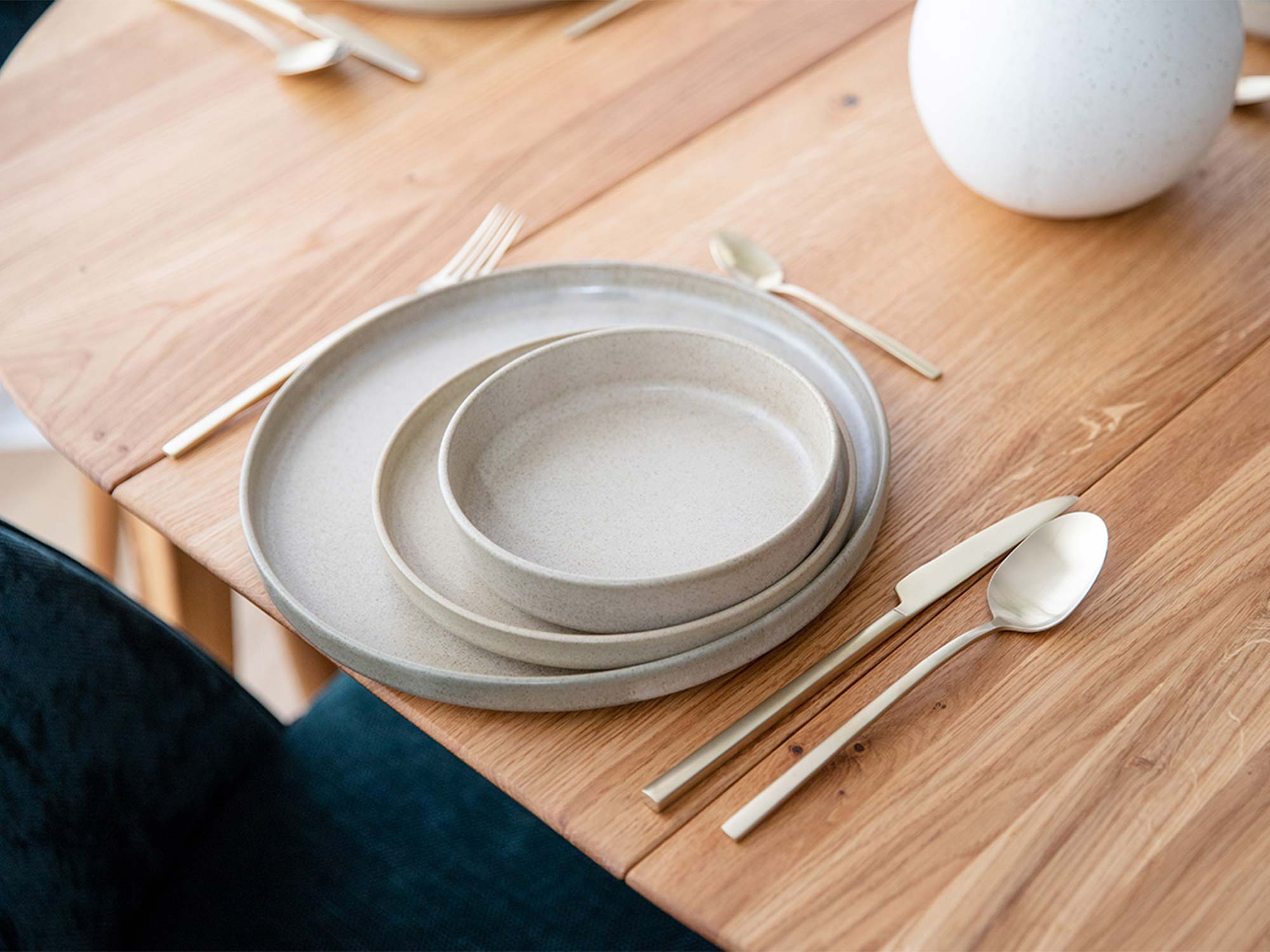 Zbliżenie na blat stołu dębowego z szarą ceramiczną zastawą